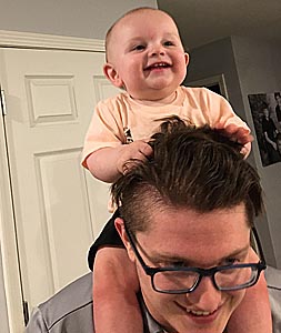 Smiling baby on his daddy's shoulders